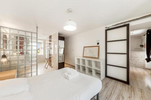- une chambre avec un lit blanc et un mur en verre dans l'établissement L'Amadea - Duplex - 3 pers au coeur de Parame, à Saint-Malo
