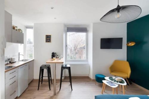 - une cuisine avec une table et deux tabourets dans une pièce dans l'établissement L'éden studio moderne et lumineux proche centre, à Rennes
