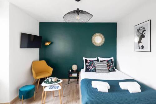 - une chambre avec un lit bleu et un mur vert dans l'établissement L'éden studio moderne et lumineux proche centre, à Rennes