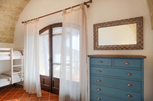 a bedroom with a blue dresser and a window at Villa Alymir in Torre Mozza
