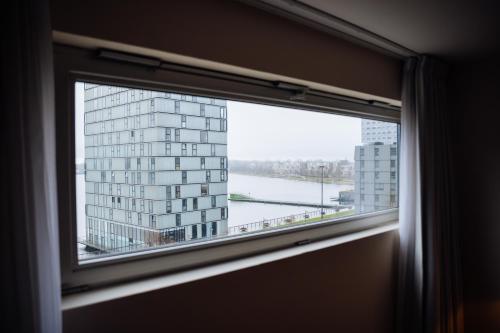 a window with a view of a building at Leonardo Hotel Almere City Center in Almere