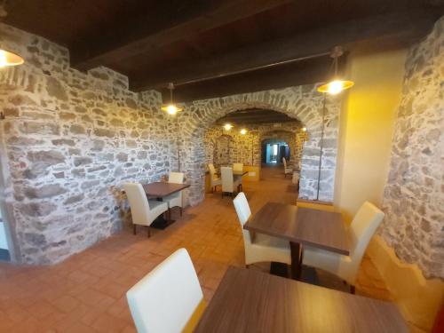 a restaurant with tables and chairs and a stone wall at Albergo Palazzo Costa in Beverino