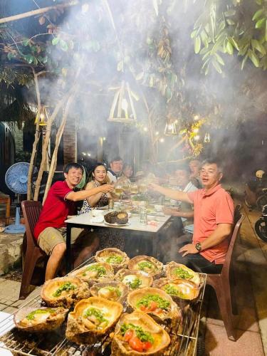 a group of people sitting around a table with food at BA DŨNG VILLA COFFEE - ĐẢO PHÚ QUÝ - Bình Thuận in Cu Lao Thu