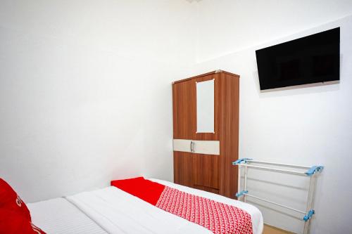 a bedroom with a bed and a tv on the wall at Hotel O Medan near Universitas Sumatera Utara formerly Surya Residence in Sunggal