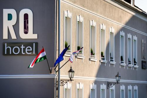 three flags on a pole in front of a hotel at RQ Boutique & Unique Hotel in Győr
