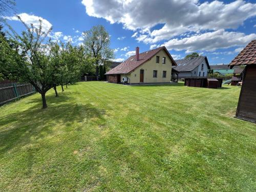 a large yard with a house and a tree at Chata Hluchavka II in Arnoltice u Decina