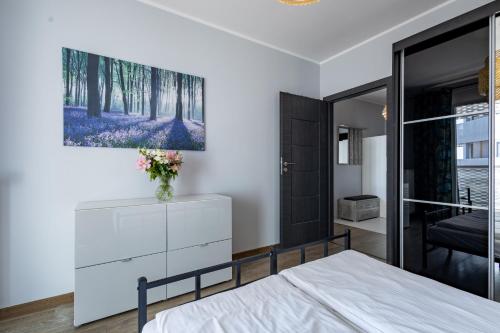 a bedroom with a bed and a painting on the wall at Apartamenty City Tower od WroclawApartament-pl in Wrocław