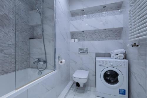 a bathroom with a washing machine and a toilet at Apartamenty City Tower od WroclawApartament-pl in Wrocław