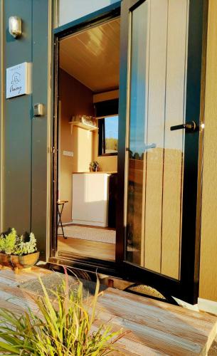 an open glass door of a building with a balcony at Perrys North by Tiny Away in Forth
