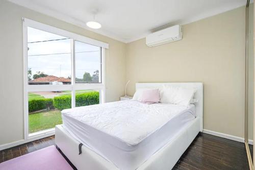 En eller flere senge i et værelse på Sydney Moorebank 4 bed house close Liverpool