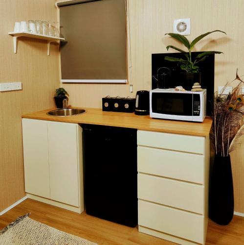 a kitchen with a counter with a microwave and a sink at Perrys North by Tiny Away in Forth