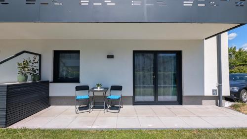 a patio with chairs and a table in front of a house at InnBlue Apartment in Braunau am Inn