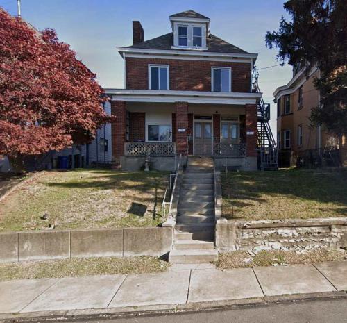 a large brick house with a staircase in front of it at Stunning 3BR-Private Entrance-Renovated-Near City in Pittsburgh