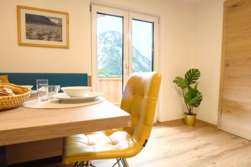 a dining room with a table and a yellow chair at Apartment MarLen in Eben am Achensee