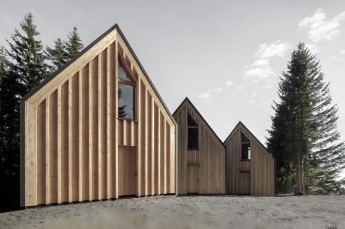 a group of three houses with wooden siding at Waldchalets Obomilla in Maranza
