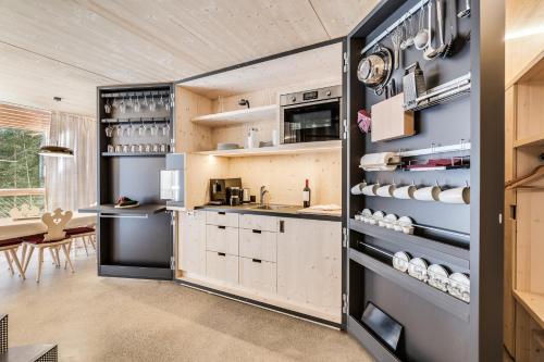 a kitchen with white cabinets and a counter top at Waldchalets Obomilla in Maranza