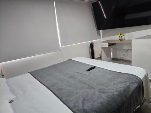 a room with a bed with a remote control on it at Apartamento Guatapé Plaza in Guatapé