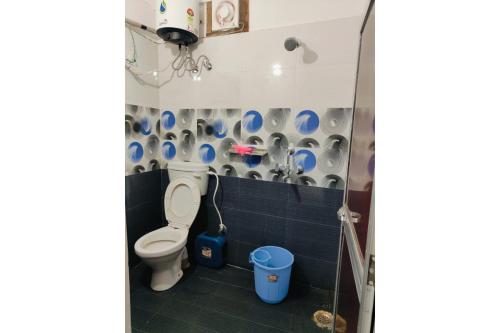 a bathroom with a toilet and a blue tiled wall at Hotel Patna Sahib Inn in Patna