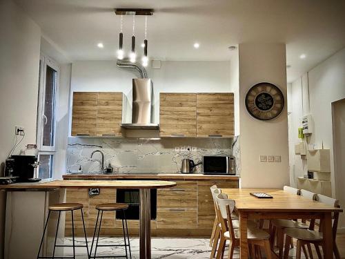 une cuisine avec des armoires en bois et une table et des chaises dans l'établissement PARIS CITY-Le Raincy - Facing station - 4 to 8 Pers, à Le Raincy