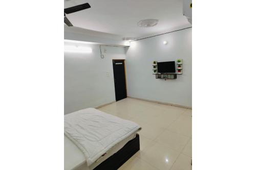 a room with a bed and a tv on a wall at Hotel Patna Sahib Inn in Patna
