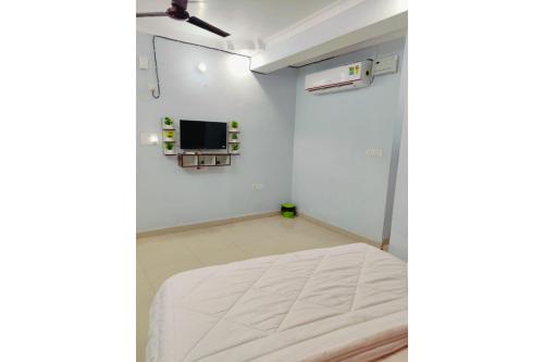 a room with a bed and a tv on a wall at Hotel Patna Sahib Inn in Patna