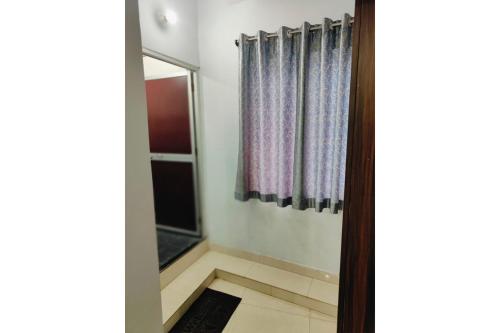 a bathroom with a shower curtain and a window at Hotel Patna Sahib Inn in Patna
