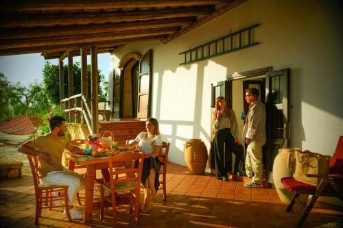 a group of people sitting around a table on a patio at Villa Alymir in Torre Mozza