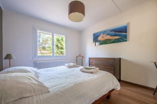 una camera da letto con un letto bianco e una finestra di Appartements parc Pereire ad Arcachon