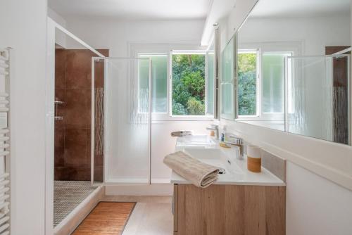 un bagno bianco con lavandino e doccia di Appartements parc Pereire ad Arcachon