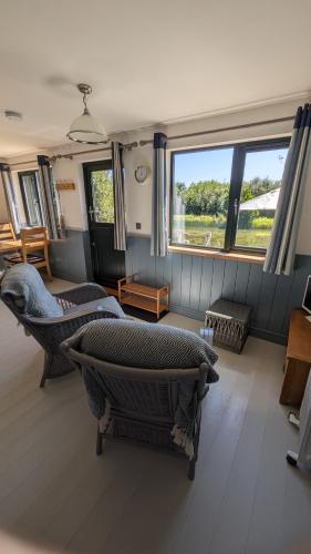 a living room with chairs and a large window at Lynstone Lakes in Bude