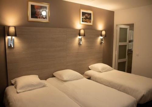 two beds in a hotel room with lights on the wall at Paris Rooms & Dreams Hotel in Paris