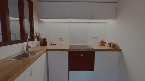 a kitchen with white cabinets and a sink at La Maison de Victoire et Alix in Pontrieux