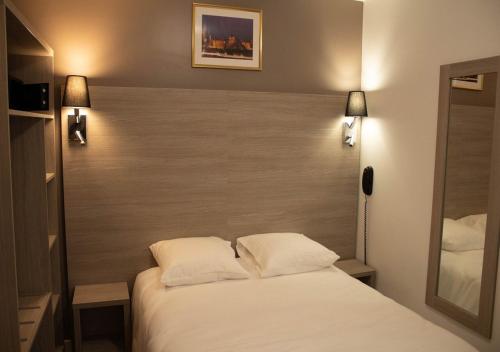 a bedroom with a white bed with two pillows at Paris Rooms & Dreams Hotel in Paris