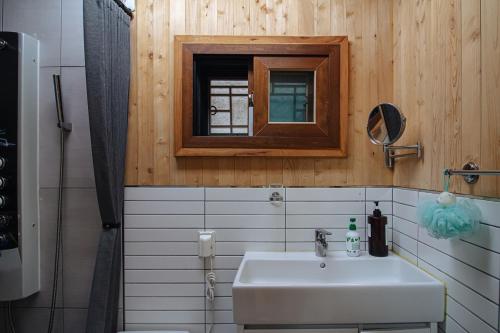 Un baño con lavabo, espejo y ducha. en Eunpyeong Hanok Pyeonganchae, en Seúl
