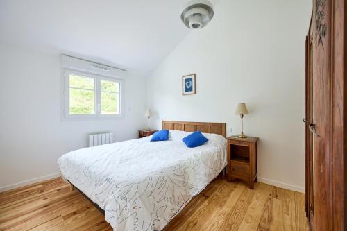a bedroom with a bed with blue pillows on it at La Maison Valnotte - Proche du port de Carteret in Barneville-Carteret