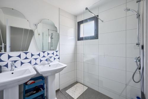 a white bathroom with a sink and a shower at La Maison Valnotte - Proche du port de Carteret in Barneville-Carteret