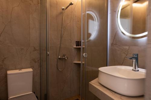 a bathroom with a shower and a sink and a toilet at Bali Seaside Sailor in Balíon