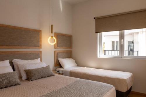 a room with two beds and a window at Bali Seaside Sailor in Balíon