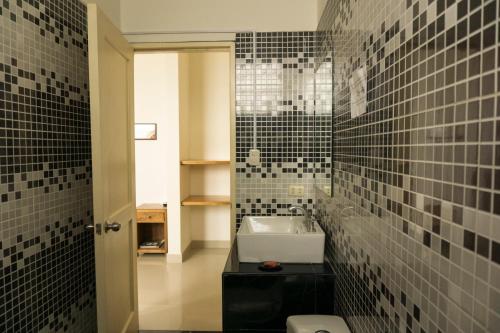 a bathroom with a sink and a black tiled wall at Don Giovanni Mancora in Máncora