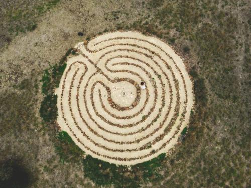 a large white spiral labyrinth in the grass at River Ridge Tiny House by Tiny Away in South Arm