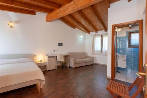 a bedroom with a bed and a desk and a bathroom at B&B Pettirosso in San Teodoro
