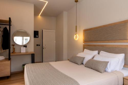 a bedroom with a large white bed and a mirror at Bali Seaside Sailor in Balíon