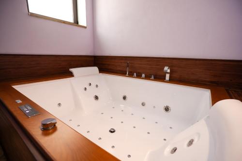a white bath tub in a bathroom with a window at Villa Amoroso - Ospitalità Mediterranea in Agrigento