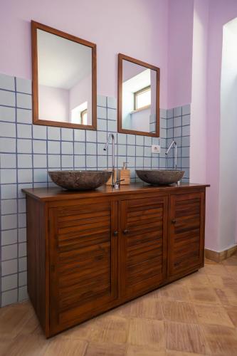 two sinks in a bathroom with two mirrors at Villa Amoroso - Ospitalità Mediterranea in Agrigento