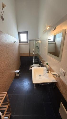 a bathroom with a sink and a toilet and a mirror at Sunset affittacamere in Cannole