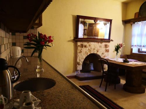a kitchen with a table and a dining room with a fireplace at Hoyran Wedre Country Houses in Davazlar