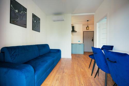 a living room with a blue couch and blue chairs at AboutArtApartments - By the river in Wrocław