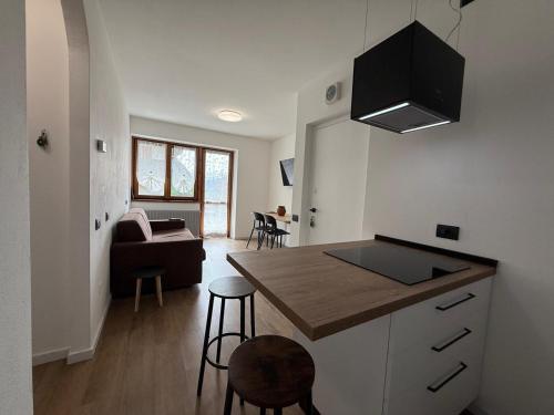 a kitchen and living room with a couch and a table at Appartamento Palu in Chiesa in Valmalenco