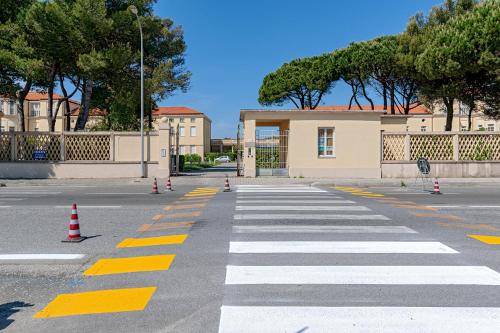 an empty street with a crosswalk in front of a building at Homiday -Gioiello Vista Mare- Parcheggio Privato in Calambrone