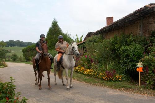 deux hommes à cheval sur une route dans l'établissement Ferme De Montalibord, à Vescours